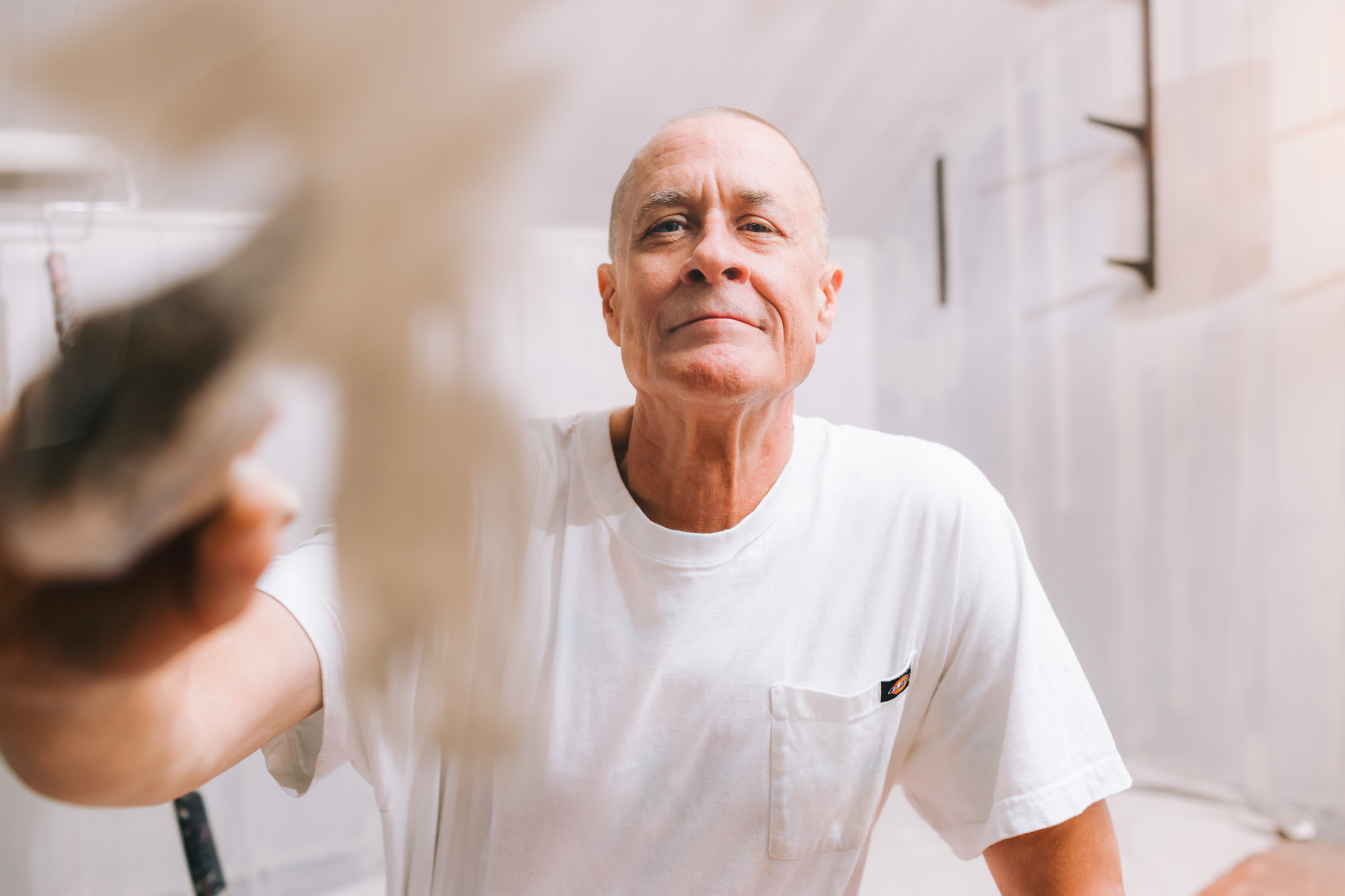 a personal branding portrait of a professional handyman painting with precision using a white brush, capturing his expertise.