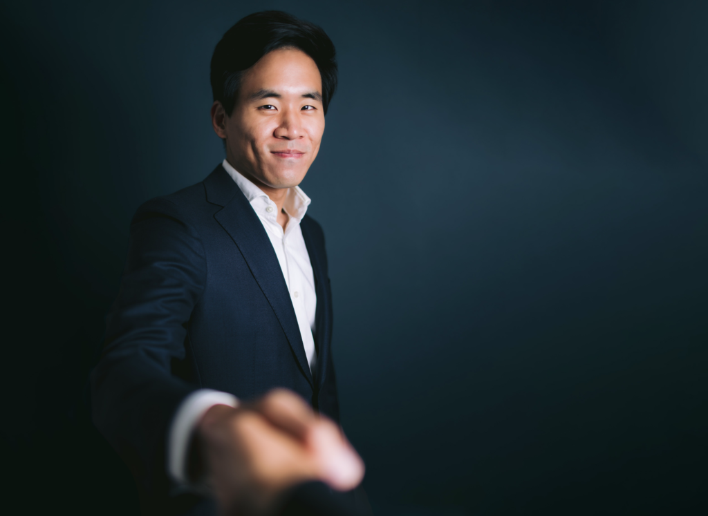 a professional realtor in a tailored suit shaking hands with a client, highlighting confidence and connection during a branding photoshoot.