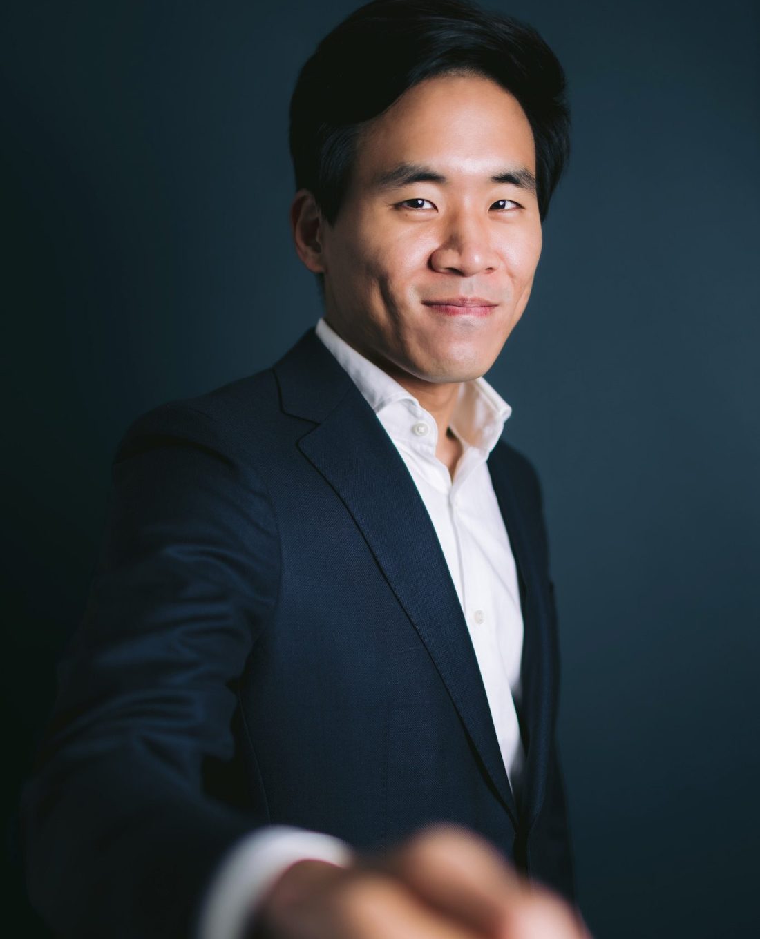 a suited man engaging in a handshake with a client, highlighting professionalism during a personal branding photography session.