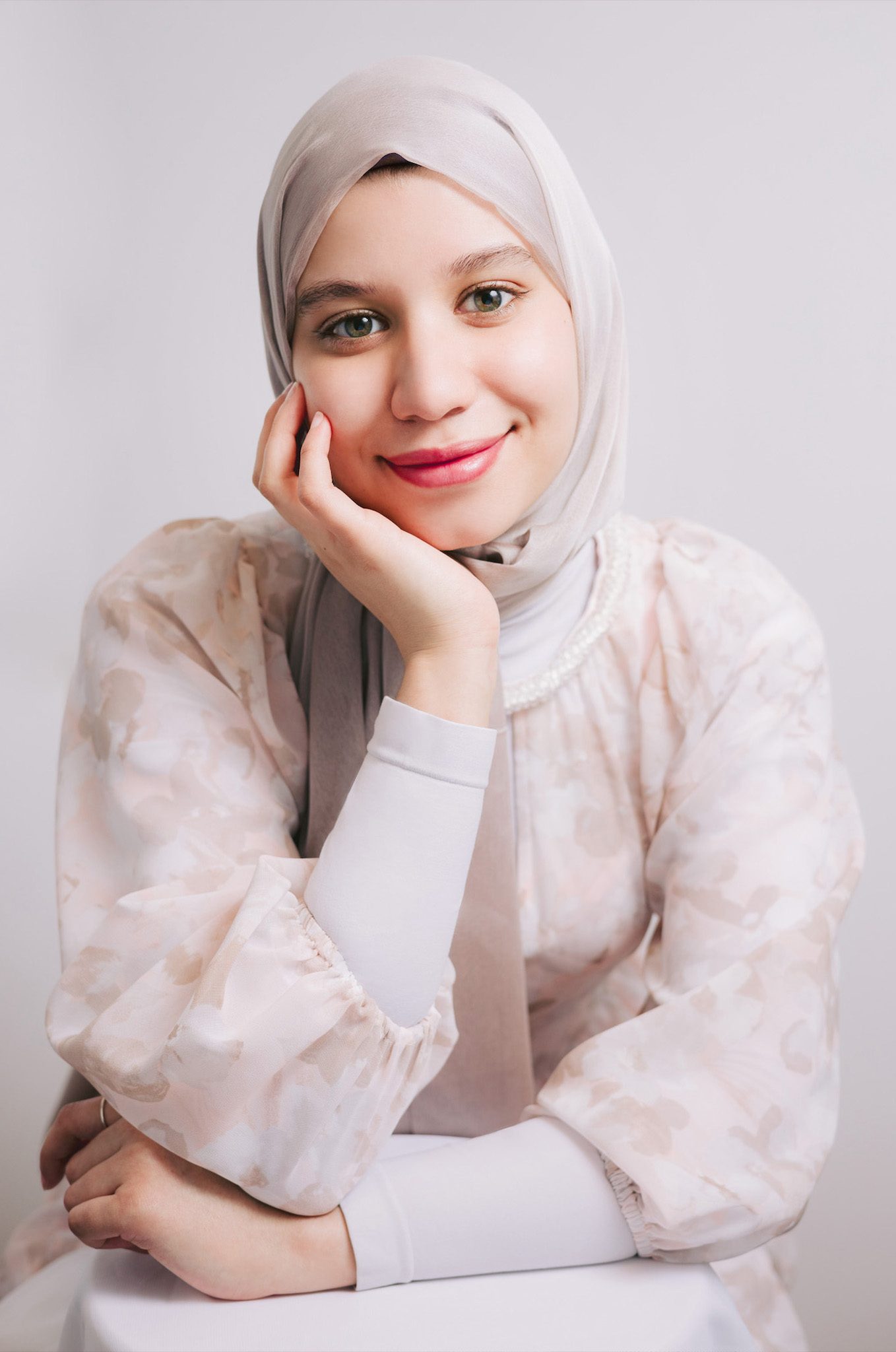 with radiating warmth and professionalism, a woman in a hijab smiles confidently for her professional headshot.